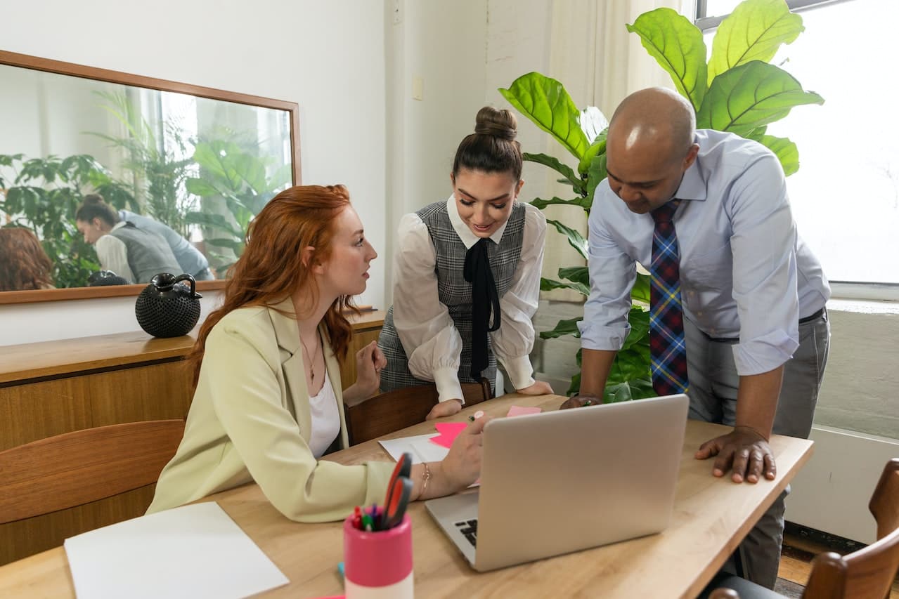 Three people discussing over the laptop